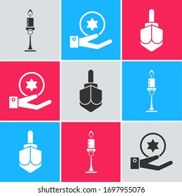 Set Burning candle in candlestick, Jewish coin on hand and Hanukkah dreidel icon. Vector