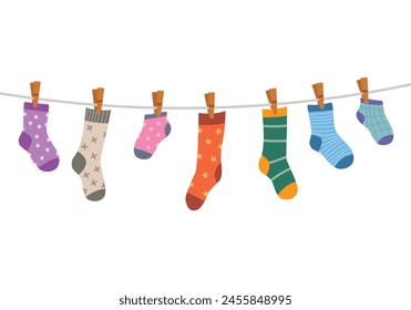 Set of children socks handing on the rope clothesline with clothespins