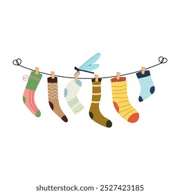 Set of children socks hanging on the rope clothesline with clothespins. Dragonfly insect. Set of different socks. Washing clothes.