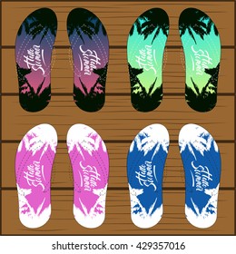 Set of colored pattern flip flops with schemed strips isolated on wooden background