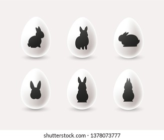 Set of decorative minimalistic white Easter eggs with black rabbit silhouettes. - Vector