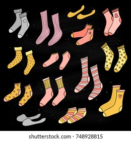 Set of different doodle golden, pink, silver socks isolated on black background.