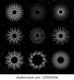 Set of different sunbursts on black background. Vector illustration
