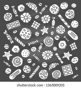 Set of doodle cookies, waffles and candies isolated on the blackboard.
