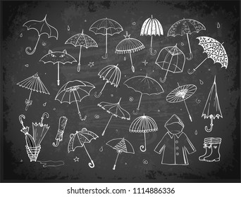 Set of doodle sketch umbrellas on blackboard background.