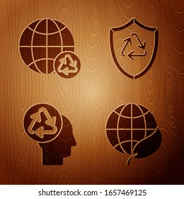 Set Earth globe and leaf, Planet earth and a recycling, Human head with recycle and Recycle symbol inside shield on wooden background. Vector