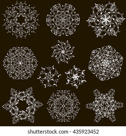 Set of elegant white snowflakes on a black background. Set of vintage snowflakes.