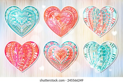 Set of ethnic patterned coloured hearts on the wood hand-drawn background for your design / card for Valentine's Day