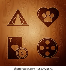 Set Film reel, Tourist tent, Casino chip and playing cards and Heart with animals footprint on wooden background. Vector