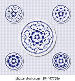 Un conjunto de cinco platos con un patrón floral azul sobre un fondo blanco de estilo folclórico ruso