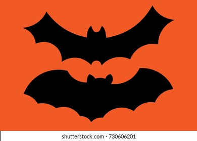 Set of flying bat silhouettes isolated on orange background. Vector illustration.