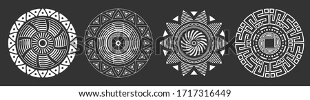 Set of four abstract circular ornaments. Decorative patterns isolated on black background. Tribal ethnic motifs. Stylized sun symbols. Stencil tattoo and prints Vector monochrome illustration.