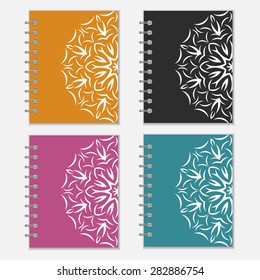Set of four colorful notebook wrappers with flower design. Orange, black, purple and blue covers with ornate pattern
