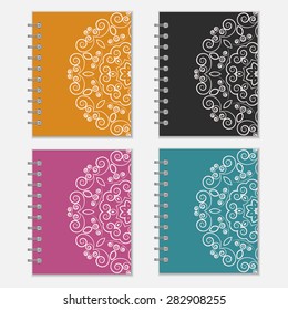 Set of four colorful notebook wrappers with flower design. Orange, black, purple and blue pocket books with ornate pattern