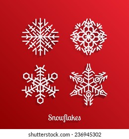 set of four silhouettes of snowflakes on a red background