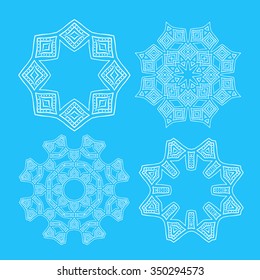 Set of four white round ornaments on blue background. Ethnic mandalas. Vector art