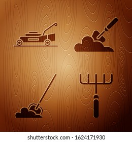 Set Garden rake, Lawn mower, Shovel in the ground and Garden trowel spade or shovel in the ground on wooden background. Vector