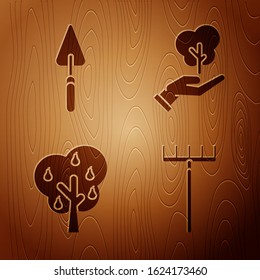 Set Garden rake, Garden trowel spade or shovel, Tree with pears and Tree in hand of environmental protection on wooden background. Vector