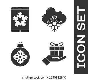 Set Geschenkbox in der Hand, Weihnachten auf Smartphone und Schneeflocke, Weihnachtsball und Cloud mit Schnee-Symbol. Vektorillustration