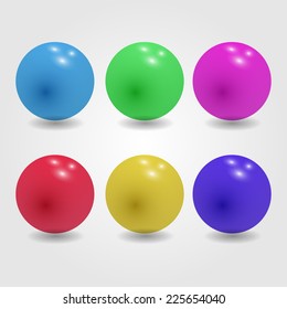 Set of glossy colored balls on grey background.