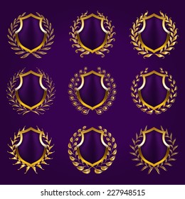Set of golden vector shields with laurel wreath. Heraldic emblems with place for text on the background.