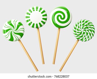 Set of green christmas candy on wooden stick. Striped peppermint lollipops isolated on white