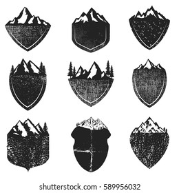 Set of Grunge badges with mountains isolated on white background. Design elements for logo, lalbel, emblem, sign. Vector illustration.