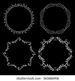 Set of hand drawn decorative frames. A set of four decorative frames. Set of decorative doodle wreaths made of branches. Black background. Black and white.
