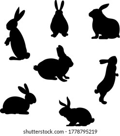Set of hand-drawn running, looking up and sitting in various poses rabbits black silhouette . Set of Easter bunny outlines isolated on white background. Simple cartoon bunny.