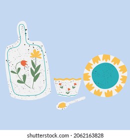 Set of handmade speckled ceramic kitchenware. Ceramic cuttingboard, bowl, plate and spoon in white color with flower elements. Vector illustration in flat cartoon style.