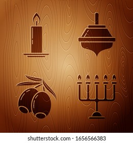 Set Hanukkah menorah, Burning candle in candlestick, Olives branch and Hanukkah dreidel on wooden background. Vector