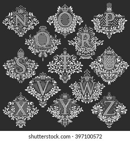 Set of heraldic monograms in coats of arms form. White floral decorative stamps of letters from N to Z. Isolated tattoo labels in vintage baroque style.