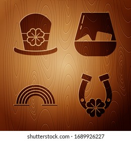 Set Horseshoe with four leaf clover, Leprechaun hat and four leaf clover, Rainbow and Glass of whiskey on wooden background. Vector