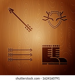 Set Hunter boots, Hipster arrow, Hipster arrows and Deer antlers on shield on wooden background. Vector