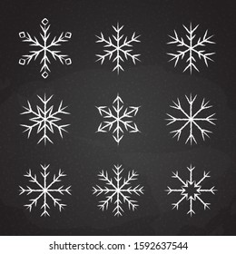 Set of icy snowflakes symbol vector illustration. White chalk sketch frozen snowflake isolated on blackboard for new year celebration snow decoration ornament or christmas festive frost flakes design