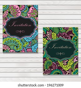 Set of invitation or wedding cards with floral background and elegant floral elements. Placed on wooden background. eps10