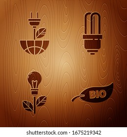 Set Leaf Bio symbol, Electric saving plug in leaf, Light bulb with leaf and LED light bulb on wooden background. Vector