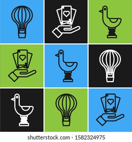 Set line Hot air balloon, Riding kid duck and Hand holding playing cards icon. Vector
