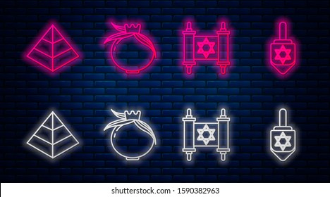 Set line Pomegranate, Torah scroll, Egypt pyramids and Hanukkah dreidel. Glowing neon icon on brick wall. Vector