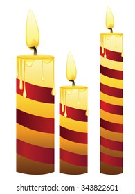 Set of lit candles in different sizes.