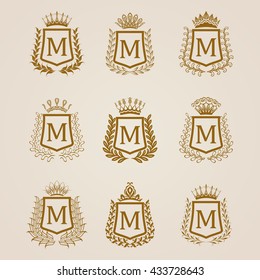 Set of luxury golden shields with laurel wreaths, crowns. Royal heraldic elements, emblems, icons, symbols, labels, badges, blazons, monograms for web, page design. Vector illustration EPS 8