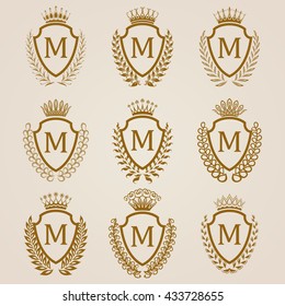 Set of luxury golden shields with laurel wreaths, crowns. Royal heraldic elements, emblems, icons, symbols, labels, badges, blazons, monograms for web, page design. Vector illustration EPS 8