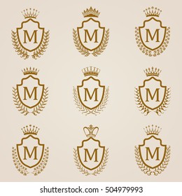 Set of luxury golden shields with laurel wreaths, crowns. Royal heraldic elements, emblems, icons, symbols, labels, badges, blazons, monograms for web, page design. Vector illustration EPS 8