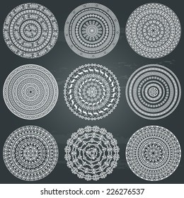 Set of nine ethnic monochromatic round design elements isolated in white on chalkboard background. Could be used for invitation, card design, for pillow design, signs and others. Vector illustration 