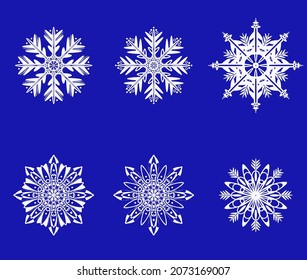A set of openwork white snowflakes on a blue background
