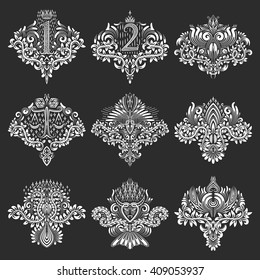 Set of ornamental elements for design in coats of arms form. White floral decorations on black. Isolated tattoo patterns in vintage baroque style.