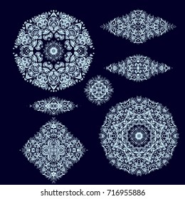 Set of ornamental rosette - snowflakes on dark blue background