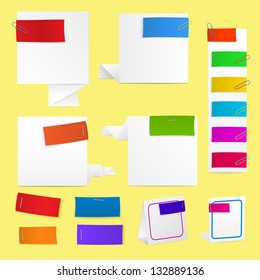 Set of paper labels in different colors with clips and staples