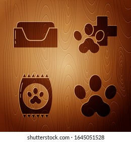 Set Paw print, Pet bed, Bag of food for pet and Veterinary clinic symbol on wooden background. Vector
