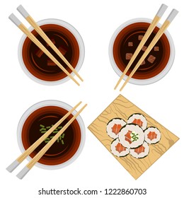 Set of portion variations of miso soup and sushi stand full with rolls.